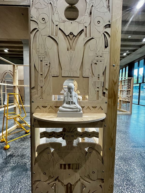 Carved plywood portal with sculpture