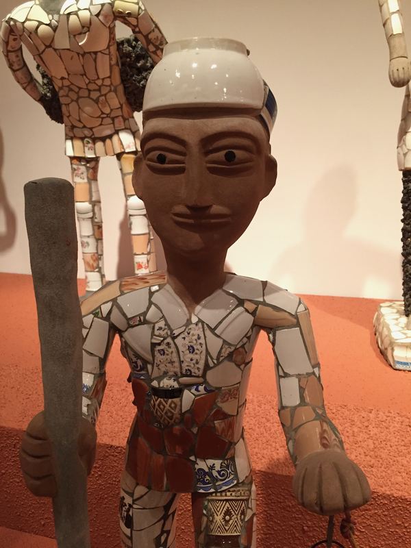 A figure clad in broken crockery